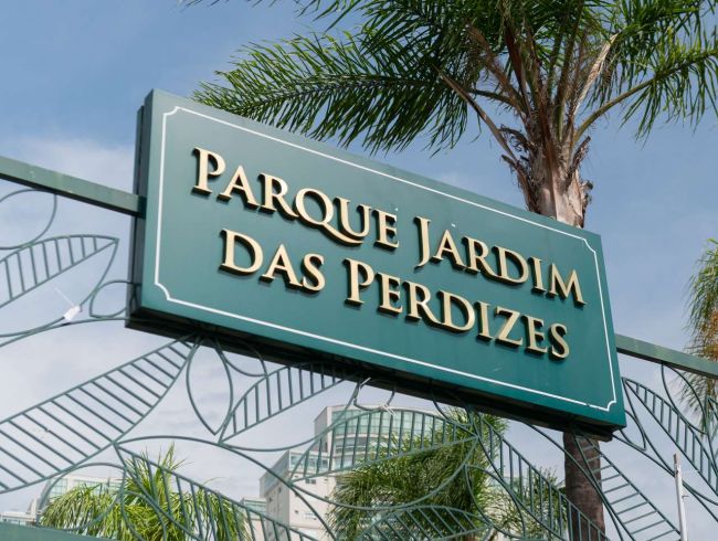 Placa de entrada do Parque Jardim das Perdizes, sobre portão de ferro trabalhado